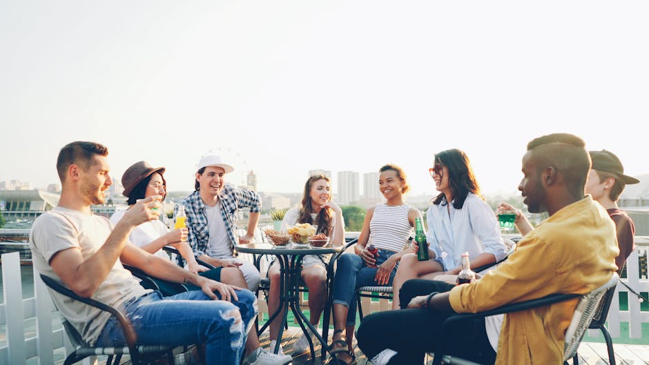 Young adults chatting at a busy rooftop party in the evening