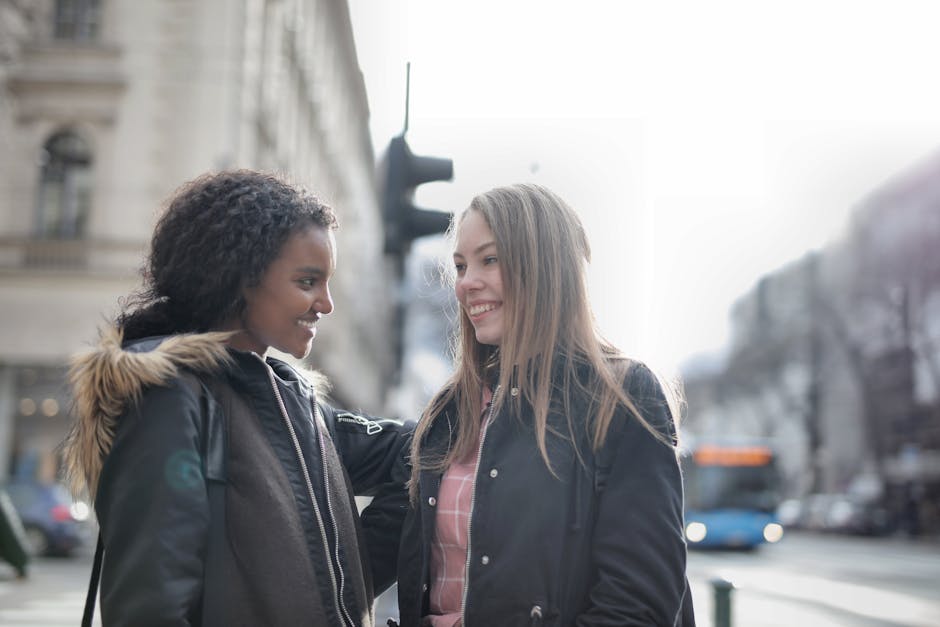 Young friends smiling while walking together through a busy urban street