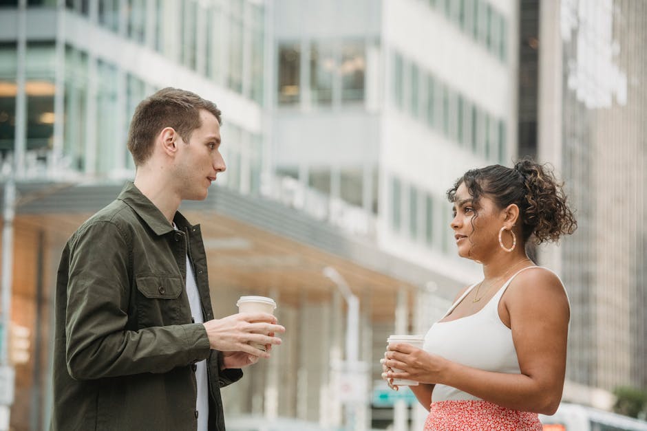 Two people drinking coffee and talking calmly at a cafe table