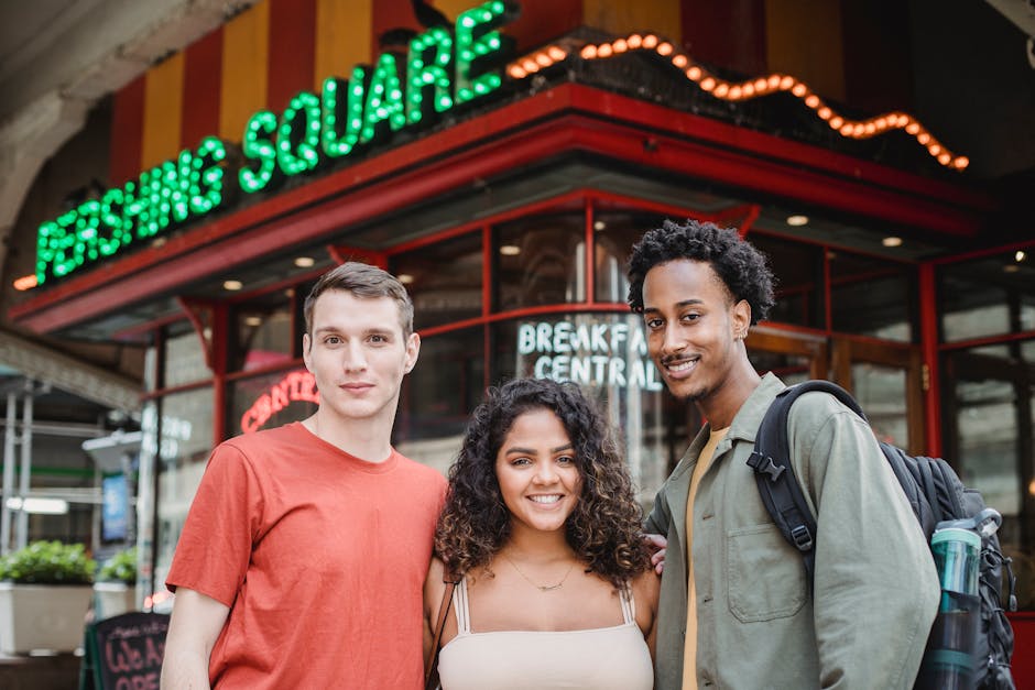 Young friends smiling together at an outdoor cafe table