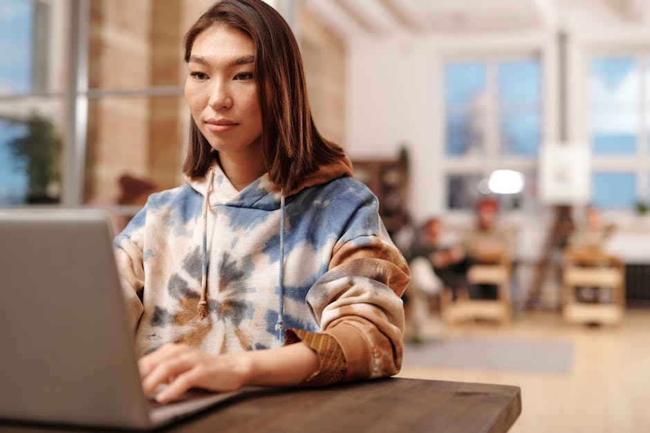 Young woman typing on a laptop in a modern coworking space