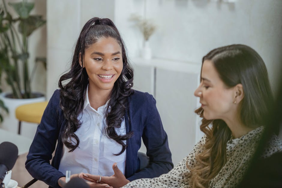 Young colleagues smiling while chatting in a casual office lounge