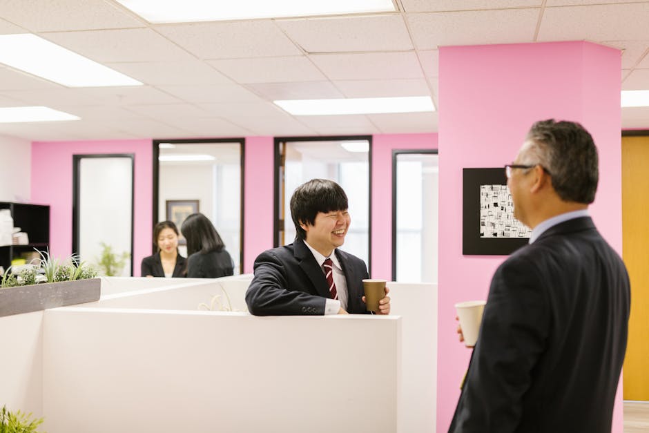 仕事場でコーヒーを片手に話す同僚たち