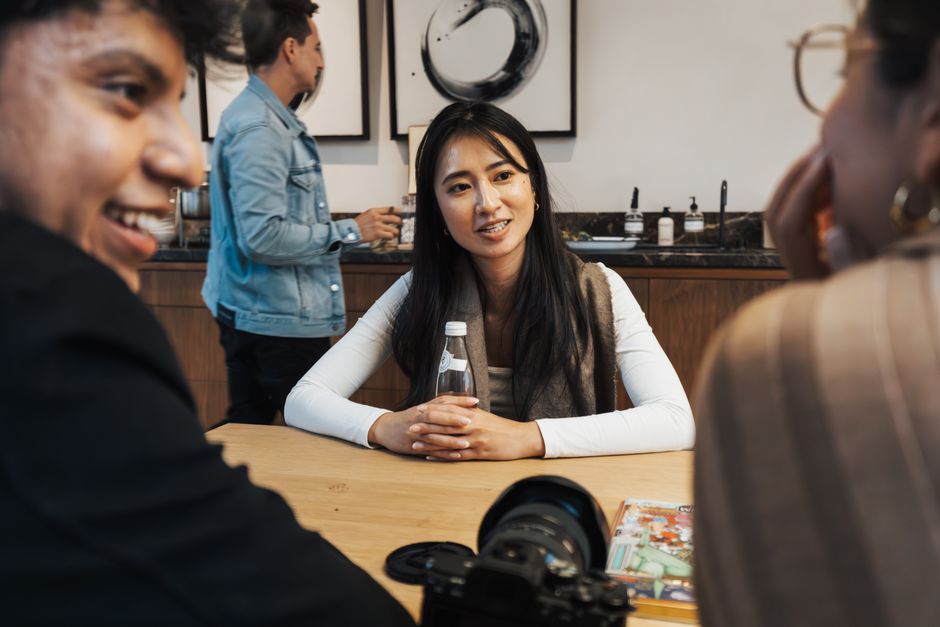 カフェのテーブルで会話する多国籍の若者たち