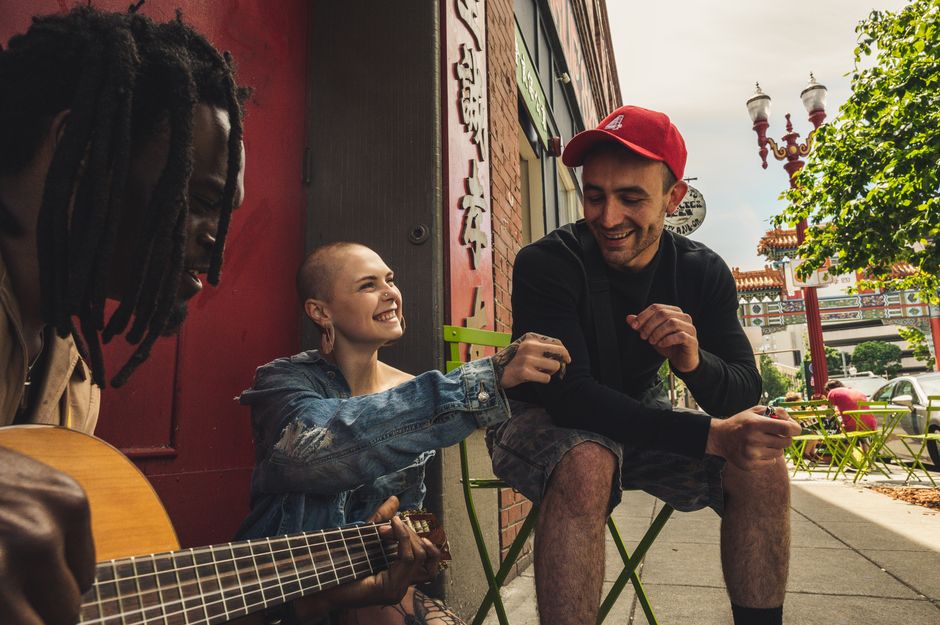 Young friends laughing together at a cafe table during a relaxed daytime meetup
