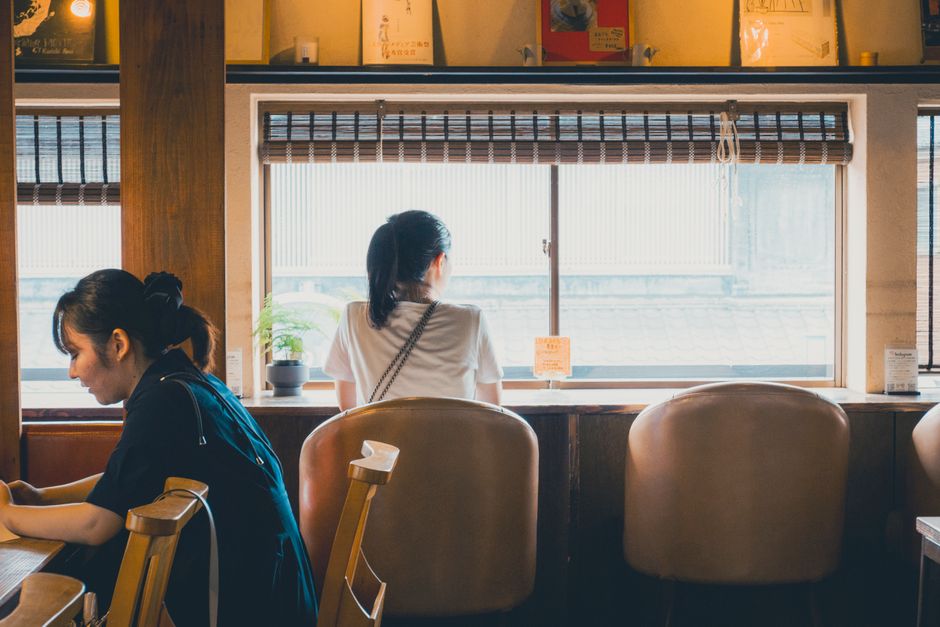 二人がコーヒー店で静かに話を聞き合う場面