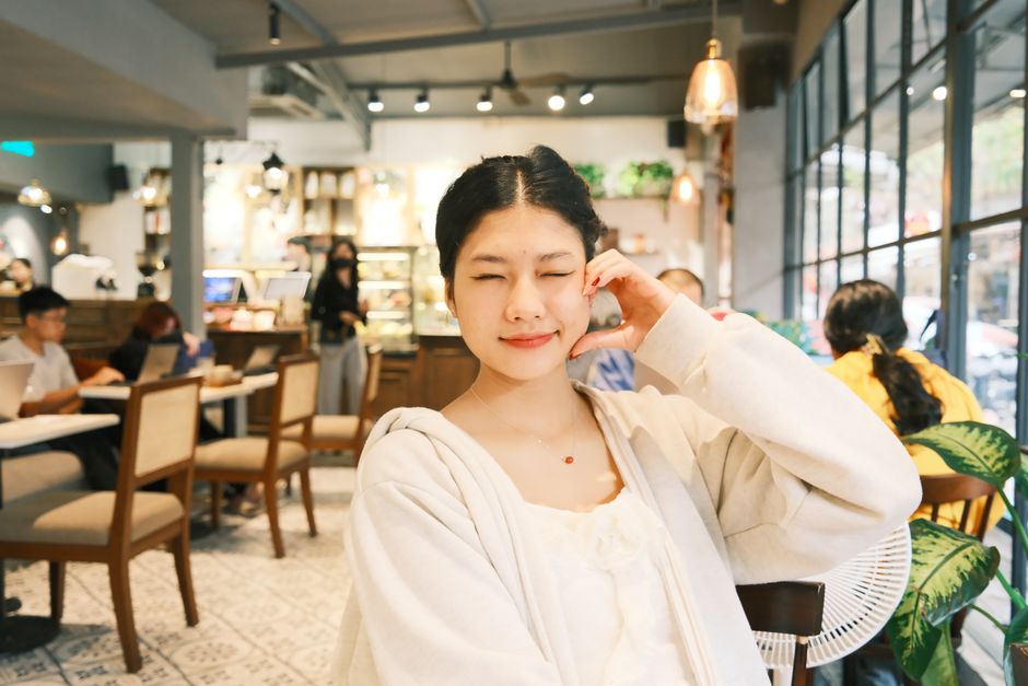 女性在咖啡廳用筆電微笑工作