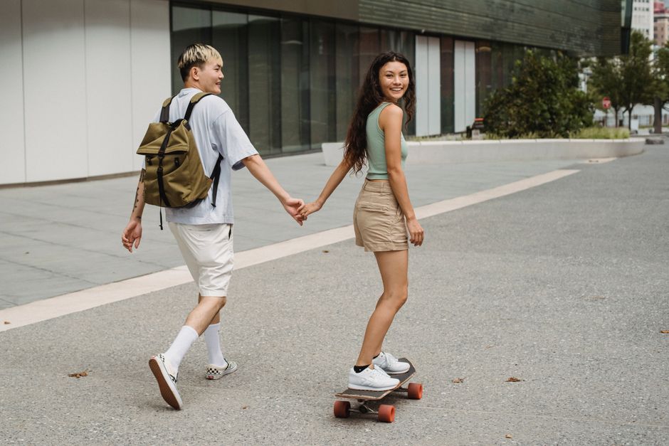 街路を歩きながら笑顔で話す若い二人