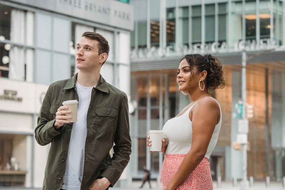 Two friends smiling while walking along a city street