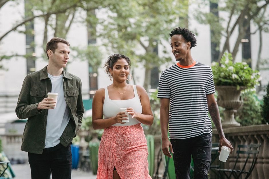 Young friends walking and smiling together on an urban street