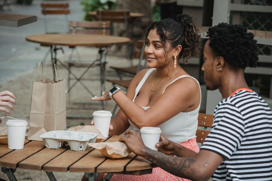 Diverse colleagues chatting comfortably inside a bright modern coffee shop