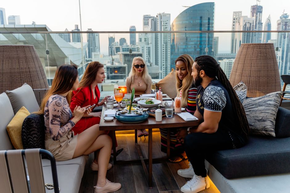 Diverse friends chatting over brunch on an outdoor terrace