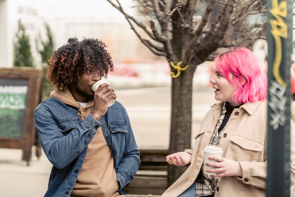 Young friends chatting while walking together on a city street