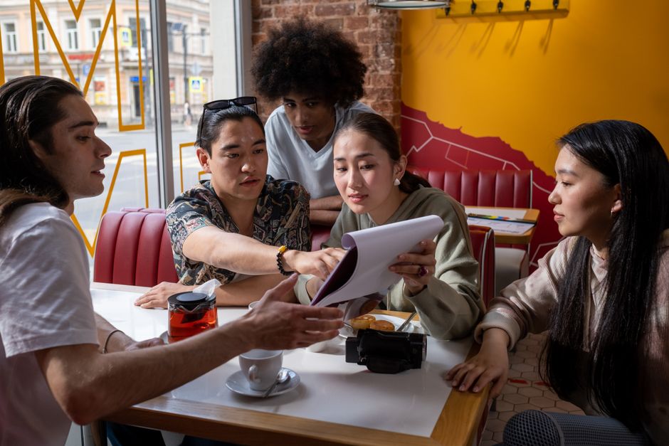 Young people plan their week together at a cafe table